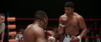 Movie still from “One Night in Miami...” (2020), directed by Regina King – Two boxers in a boxing ring , one of whom has his hands in the air; Medium shot, Over the shoulder angle