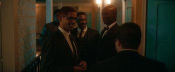 Movie still from “One Night in Miami...” (2020), directed by Regina King – A group of men standing next to each other in a room; Medium shot, Over the shoulder angle