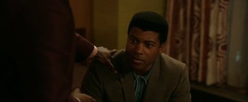 Movie still from “One Night in Miami...” (2020), directed by Regina King – A man in a suit and tie with his hand on his shoulder; Close Up shot, Over the shoulder angle