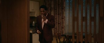 Movie still from “One Night in Miami...” (2020), directed by Regina King – A man in a suit smoking a cigarette in a kitchen; Medium shot, Over the shoulder angle