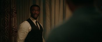 Movie still from “One Night in Miami...” (2020), directed by Regina King – A man in a vest and tie standing in front of a curtain; Close Up shot, Over the shoulder angle