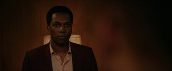 Movie still from “One Night in Miami...” (2020), directed by Regina King – A man wearing a suit and tie in a room; Close Up shot, Over the shoulder angle