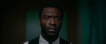 Movie still from “One Night in Miami...” (2020), directed by Regina King – A person wearing a suit and tie; Close Up shot, Low angle