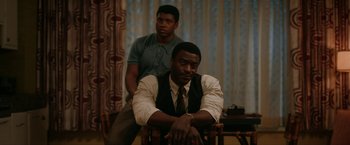 Movie still from “One Night in Miami...” (2020), directed by Regina King – Two men sitting on a chair in a living room; Medium shot, Over the shoulder angle