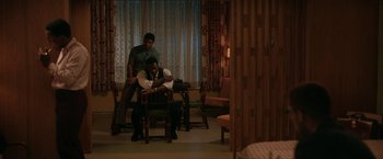 Movie still from “One Night in Miami...” (2020), directed by Regina King – A couple of men sitting on top of a wooden chair; Wide shot, High angle