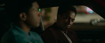 Movie still from “One Night in Miami...” (2020), directed by Regina King – A man sitting in the back seat of a car next to another man; Close Up shot, Over the shoulder angle