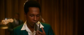 Movie still from “One Night in Miami...” (2020), directed by Regina King – A young man holding a microphone up to his mouth; Close Up shot, Over the shoulder angle