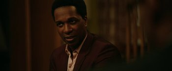 Movie still from “One Night in Miami...” (2020), directed by Regina King – A person wearing a suit and tie; Close Up shot, Over the shoulder angle