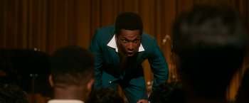 Movie still from “One Night in Miami...” (2020), directed by Regina King – A man in a green suit standing in front of a microphone; Close Up shot, Over the shoulder angle