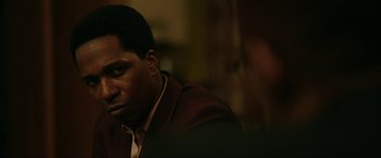 Movie still from “One Night in Miami...” (2020), directed by Regina King – A person wearing a suit and tie; Close Up shot, Over the shoulder angle