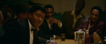 Movie still from “One Night in Miami...” (2020), directed by Regina King – A man sitting at a table with a glass of water; Close Up shot, Over the shoulder angle