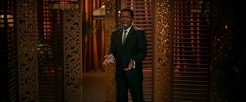 Movie still from “One Night in Miami...” (2020), directed by Regina King – A man wearing a suit and tie standing in front of a door; Medium shot, Over the shoulder angle