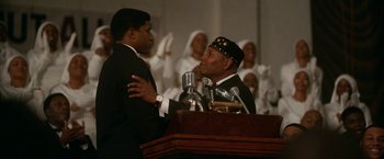 Movie still from “One Night in Miami...” (2020), directed by Regina King – Two men in suits are talking to each other in front of microphones; Medium shot, Low angle