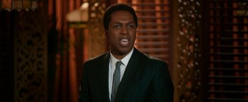 Movie still from “One Night in Miami...” (2020), directed by Regina King – A man wearing a suit and tie with his mouth wide open; Close Up shot, Over the shoulder angle