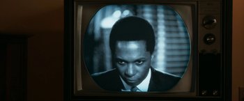 Movie still from “One Night in Miami...” (2020), directed by Regina King – A man's face on a television screen; Close Up shot, Low angle