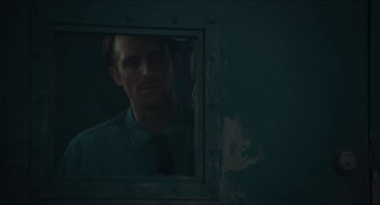 Movie still from “Orphan: First Kill” (2022), directed by William Brent Bell – A man in a green dress shirt and tie looking into a mirror; Close Up shot, Over the shoulder angle