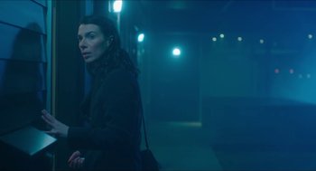 Movie still from “Orphan: First Kill” (2022), directed by William Brent Bell – A woman is standing in a dark hallway; Medium shot, Low angle