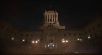 Movie still from “Orphan: First Kill” (2022), directed by William Brent Bell – A large building with a clock tower in the middle of it; Extreme Wide shot, Low angle