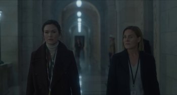 Movie still from “Orphan: First Kill” (2022), directed by William Brent Bell – Two women are walking in a hallway in a building; Medium shot, Over the shoulder angle