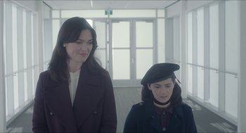 Movie still from “Orphan: First Kill” (2022), directed by William Brent Bell – Two women standing next to each other in a building; Medium shot, Low angle