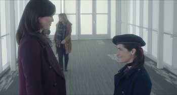 Movie still from “Orphan: First Kill” (2022), directed by William Brent Bell – Two women are standing in a room talking; Medium shot, Over the shoulder angle