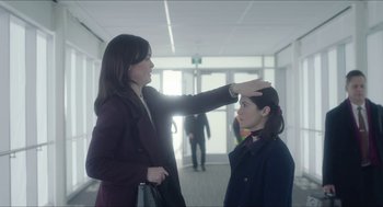 Movie still from “Orphan: First Kill” (2022), directed by William Brent Bell – A woman putting makeup on another woman's face; Medium shot, Over the shoulder angle