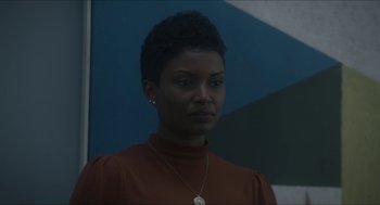 Movie still from “Orphan: First Kill” (2022), directed by William Brent Bell – A woman with short black hair wearing a brown sweater; Close Up shot, Over the shoulder angle