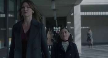 Movie still from “Orphan: First Kill” (2022), directed by William Brent Bell – Two women are walking down a hallway together; Medium shot, Over the shoulder angle