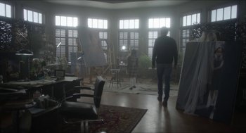 Movie still from “Orphan: First Kill” (2022), directed by William Brent Bell – A man standing in front of a window in a room; Wide shot, Over the shoulder angle