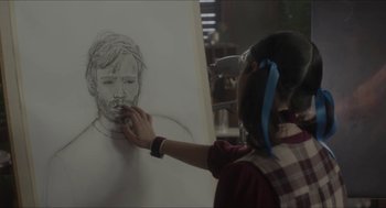 Movie still from “Orphan: First Kill” (2022), directed by William Brent Bell – A person is drawing a picture of a man; Close Up shot, Over the shoulder angle