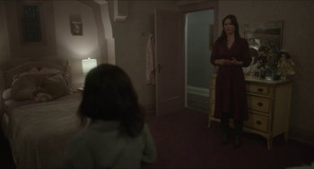 Movie still from “Orphan: First Kill” (2022), directed by William Brent Bell – A woman standing in front of a child in a room; Wide shot, Over the shoulder angle