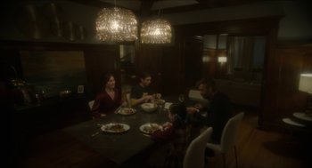 Movie still from “Orphan: First Kill” (2022), directed by William Brent Bell – A group of people sitting around a table eating; Wide shot, High angle