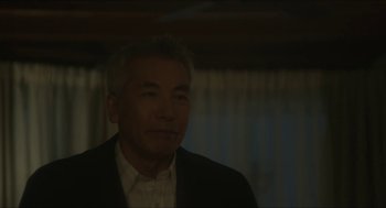 Movie still from “Orphan: First Kill” (2022), directed by William Brent Bell – An older asian man in a suit and tie; Close Up shot, Low angle