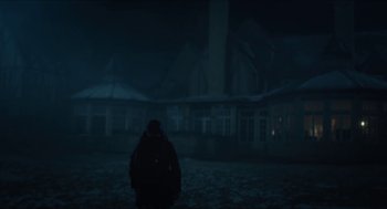 Movie still from “Orphan: First Kill” (2022), directed by William Brent Bell – A person standing in front of a building in the dark; Extreme Wide shot, Low angle