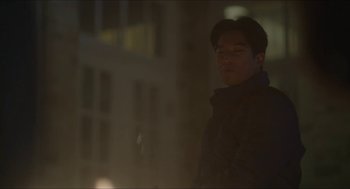 Movie still from “Orphan: First Kill” (2022), directed by William Brent Bell – A man standing in the dark in front of a building; Medium shot, Low angle