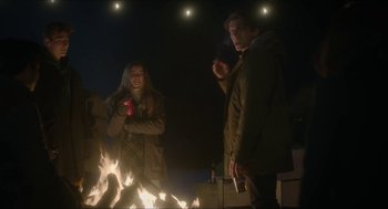 Movie still from “Orphan: First Kill” (2022), directed by William Brent Bell – A man and a woman standing in front of a fire; Medium shot, Low angle