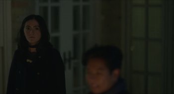 Movie still from “Orphan: First Kill” (2022), directed by William Brent Bell – Two people standing next to each other in a dark room; Medium shot, Over the shoulder angle