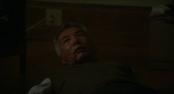 Movie still from “Orphan: First Kill” (2022), directed by William Brent Bell – An older man with a knife stuck in his face; Close Up shot, High angle