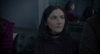 Movie still from “Orphan: First Kill” (2022), directed by William Brent Bell – A woman sitting on a couch in front of a mirror; Close Up shot, Over the shoulder angle