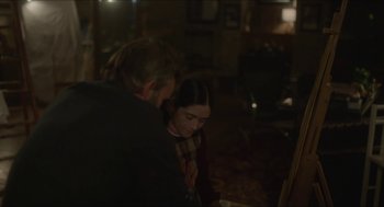 Movie still from “Orphan: First Kill” (2022), directed by William Brent Bell – A man and a woman looking at something on a table; Medium shot, Over the shoulder angle