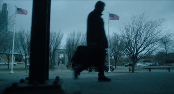 Movie still from “Orphan: First Kill” (2022), directed by William Brent Bell – A man walking down a street with a suitcase; Wide shot, Low angle