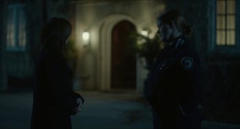 Movie still from “Orphan: First Kill” (2022), directed by William Brent Bell – Two women standing in front of a building at night; Medium shot, Over the shoulder angle