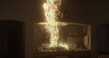 Movie still from “Orphan: First Kill” (2022), directed by William Brent Bell – A kitchen stove with a lot of flames coming out of it; Wide shot, High angle