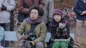 Movie still from “Our Little Sister” (2015), directed by Kore-eda Hirokazu – A man and a woman sitting next to each other on a park bench; Medium shot, Low angle