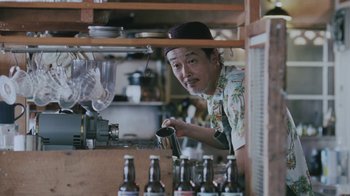 Movie still from “Our Little Sister” (2015), directed by Kore-eda Hirokazu – A man in a hat is working in a kitchen; Medium shot, Low angle