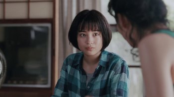 Movie still from “Our Little Sister” (2015), directed by Kore-eda Hirokazu – A woman in a plaid shirt is looking at the camera; Close Up shot, Over the shoulder angle
