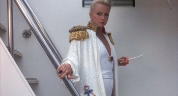 Movie still from “Overboard” (1987), directed by Garry Marshall – A woman in a white outfit holding a cigarette; Medium shot, Low angle