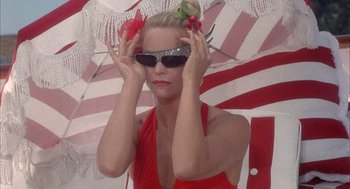 Movie still from “Overboard” (1987), directed by Garry Marshall – A woman in a red dress holding her sunglasses; Close Up shot, Low angle