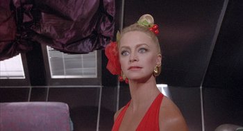 Movie still from “Overboard” (1987), directed by Garry Marshall – A woman in a red dress with a red bow in her hair; Close Up shot, Low angle