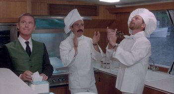 Movie still from “Overboard” (1987), directed by Garry Marshall – A group of people in a kitchen clapping; Medium shot, Low angle